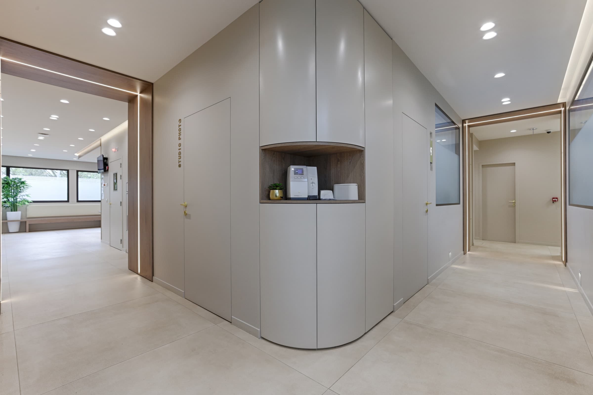 Couloir avec niche en bois éclairée intégrant un autoclave
