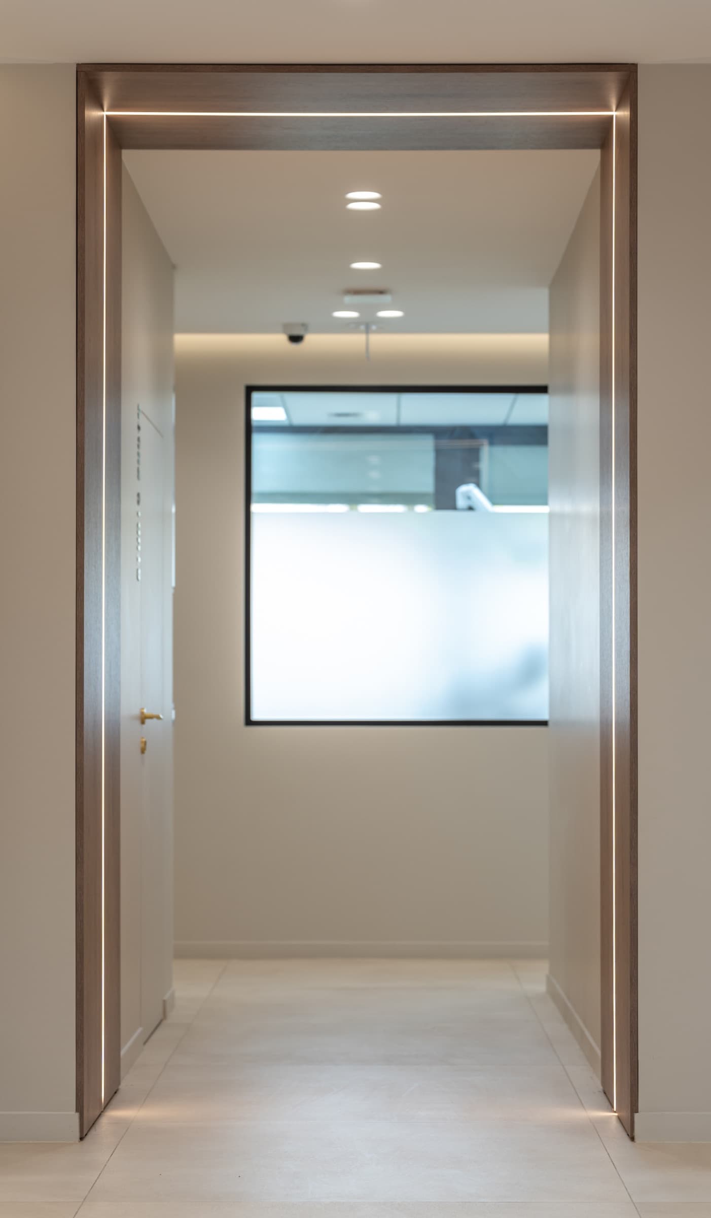 Couloir en perspective avec encadrement bois LED encastrée, porte en arrière-plan