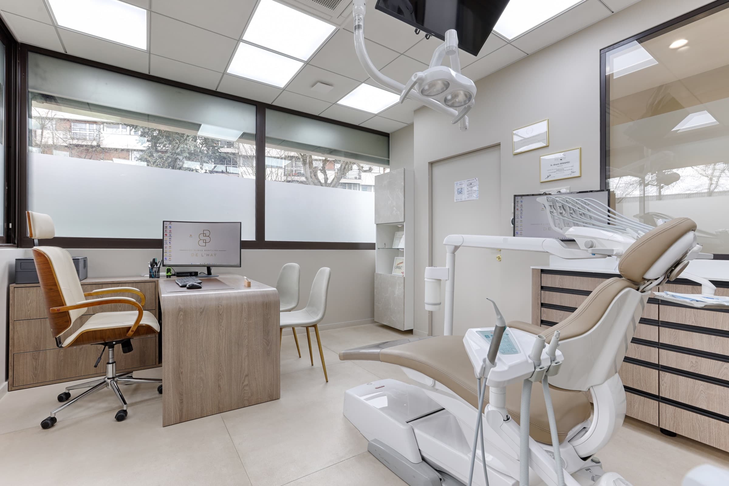 Salle de soin avec bureau, chaises de consultation et fauteuil dentaire